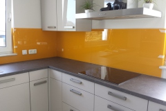 Orangene Glasrückwand in einer Küche