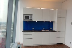 Blaue Glasrückwand hinter einer Küchenarbeitsplatte