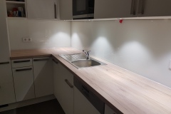 Weiße Glas-Küchenrückwand mit Steckdosen